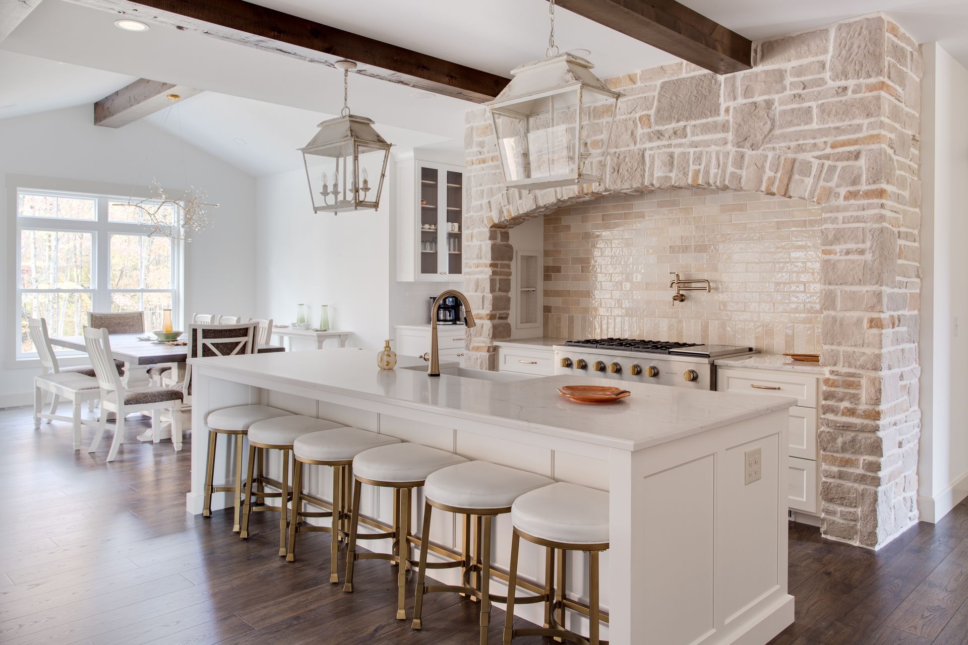 A kitchen with a large island and stools in it.