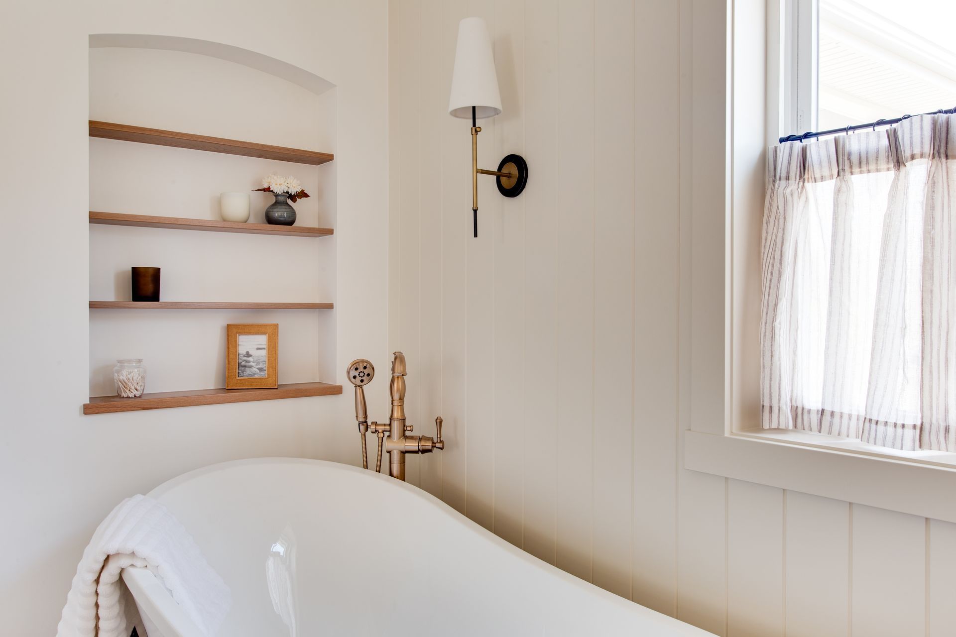 A bathroom with a claw foot tub and a window.