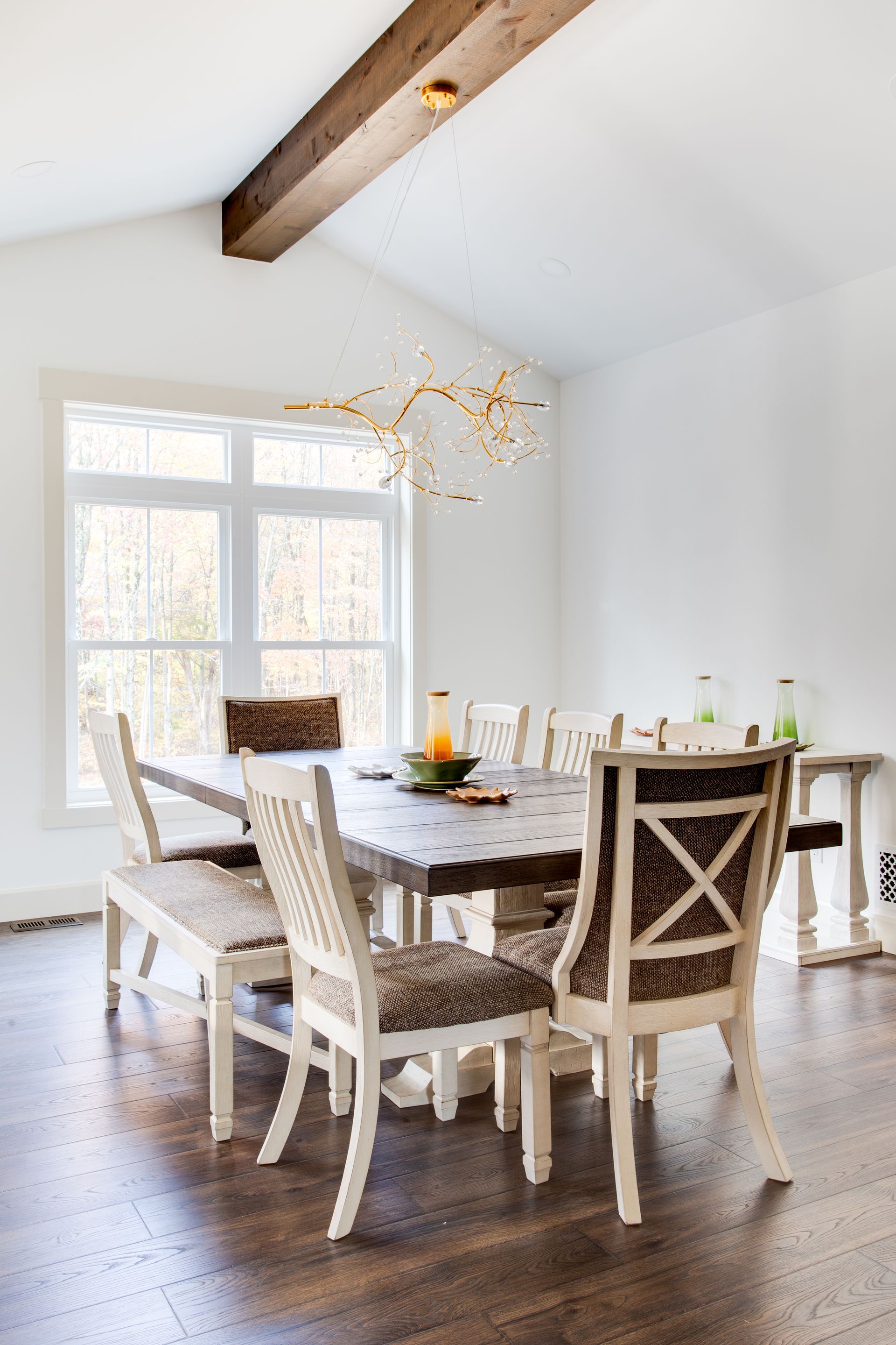 A dining room with a table and chairs and a large window.