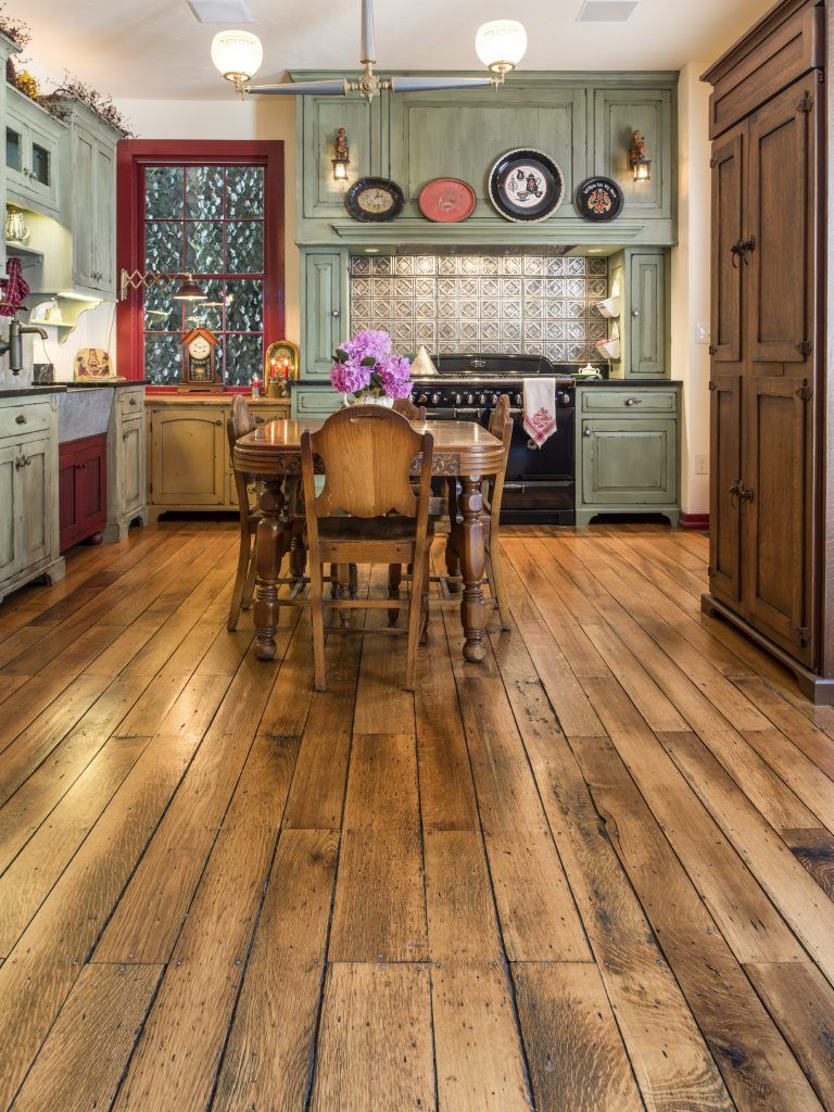 A kitchen with a wooden floor and a table and chairs.