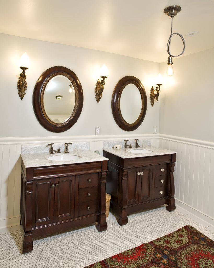 A bathroom with two sinks and two mirrors on the wall.