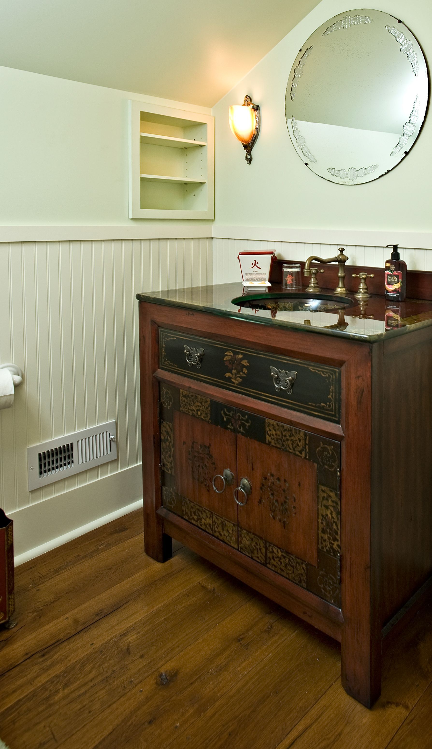 A bathroom with a wooden vanity and a mirror.