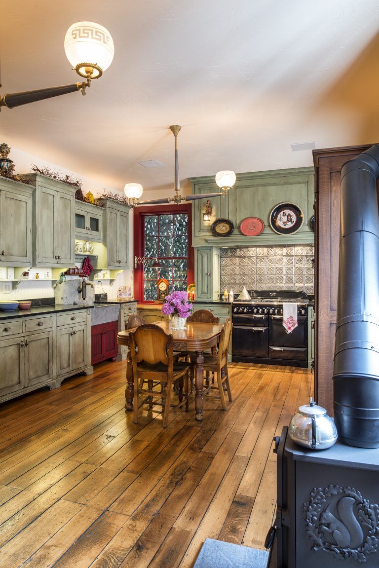 A kitchen with a table and chairs and a wood stove.