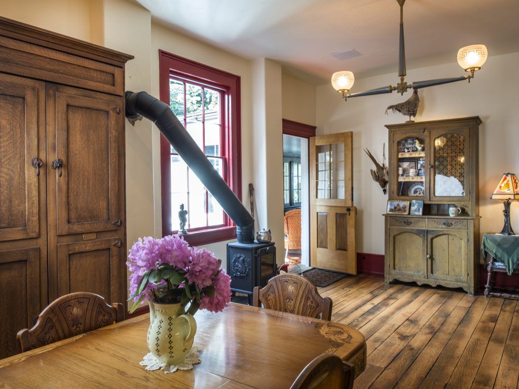 A dining room table with a vase of flowers on it.