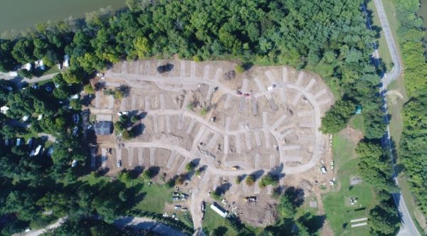 An aerial view of a campground surrounded by trees and a lake.