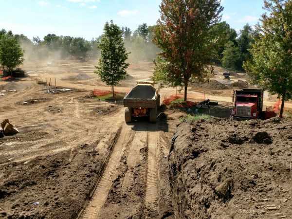 A dump truck is driving down a dirt road.