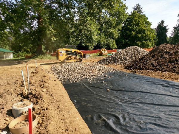 A construction site with a bulldozer and piles of dirt.