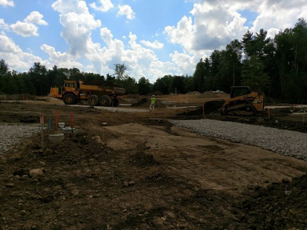 A construction site with a bulldozer and a dump truck.