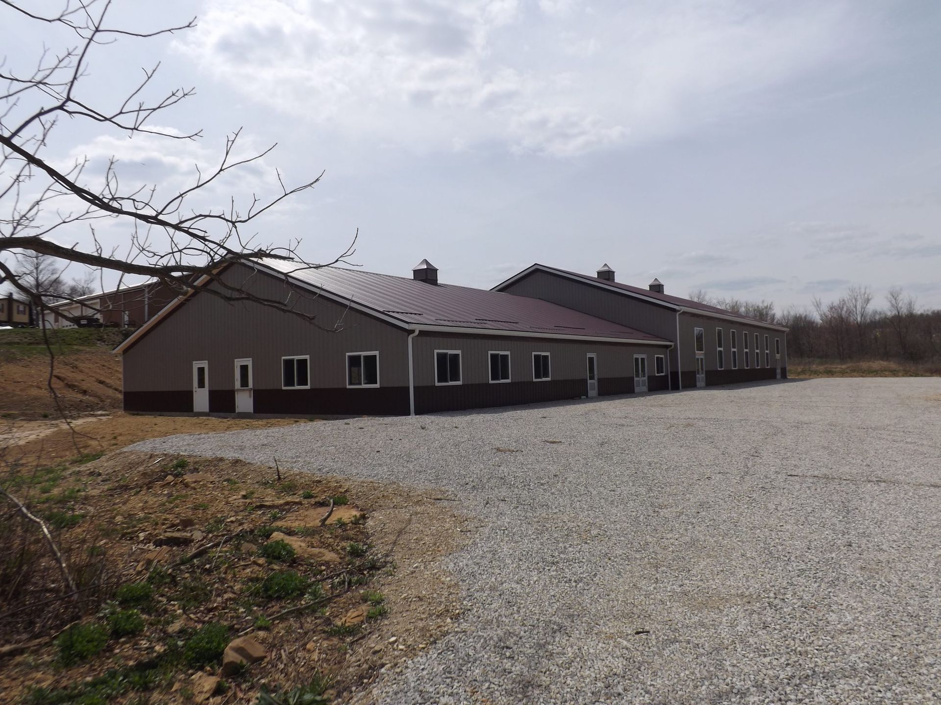 A large building with a gravel driveway in front of it.