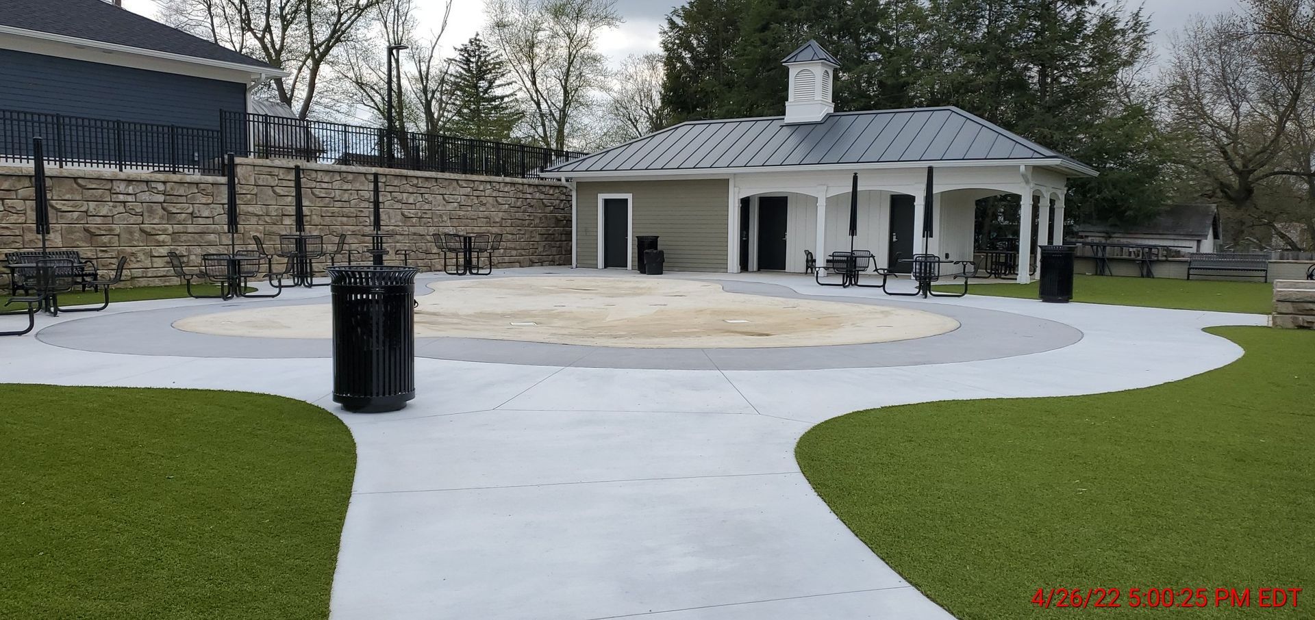 A concrete walkway leading to a building in a park.