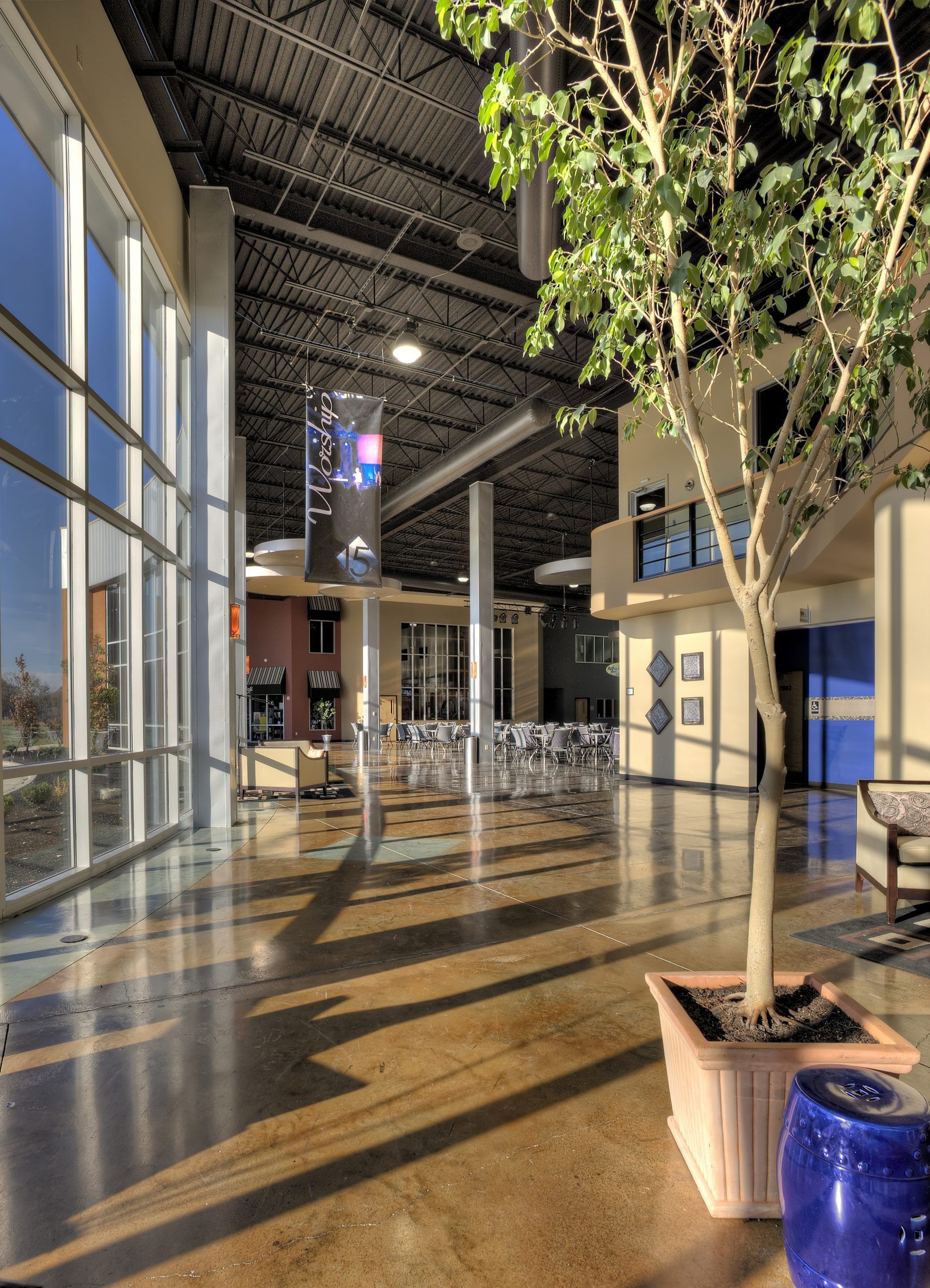 A large building with lots of windows and a tree in the middle.