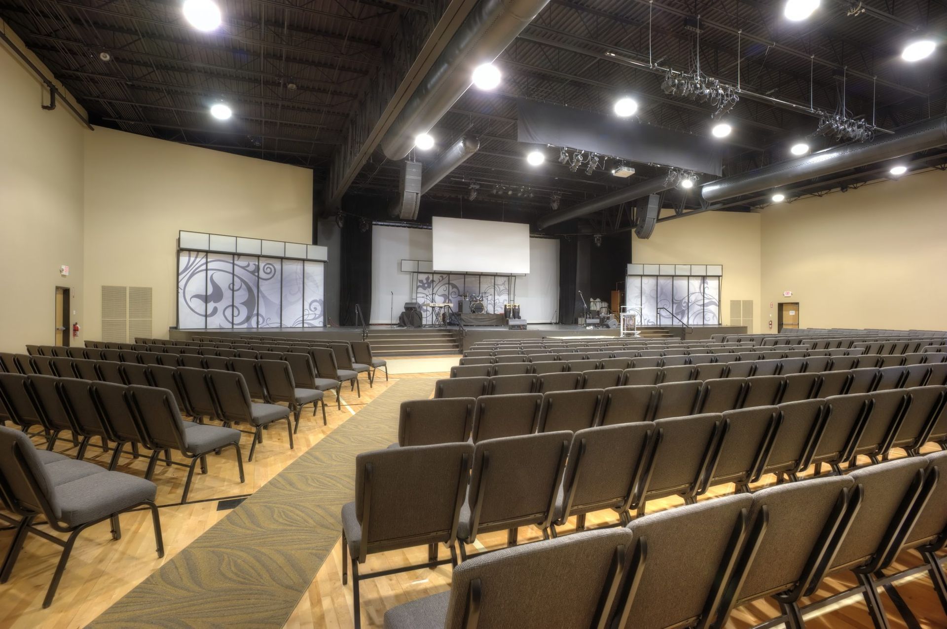 A large auditorium with rows of chairs and a stage.