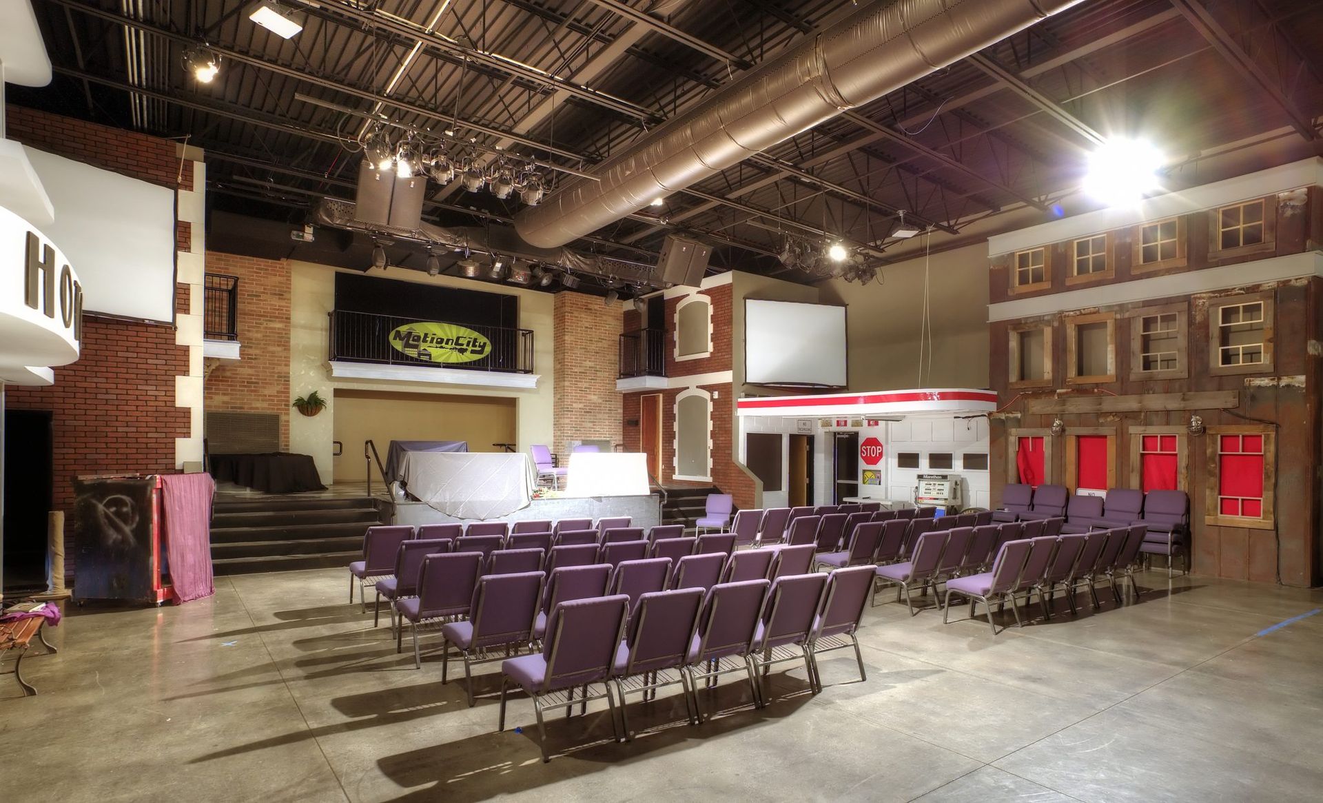 A large auditorium with purple chairs and a stage