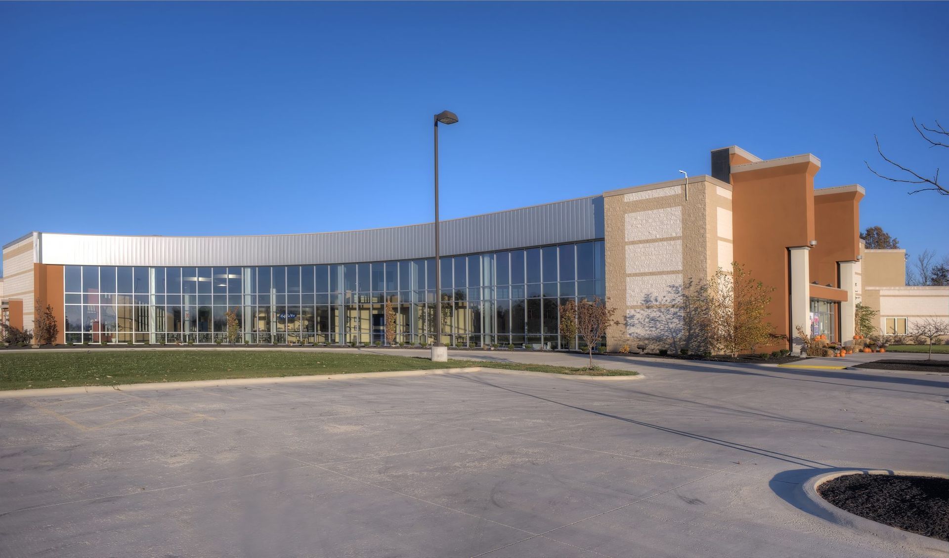 A large building with a lot of windows and a parking lot in front of it.