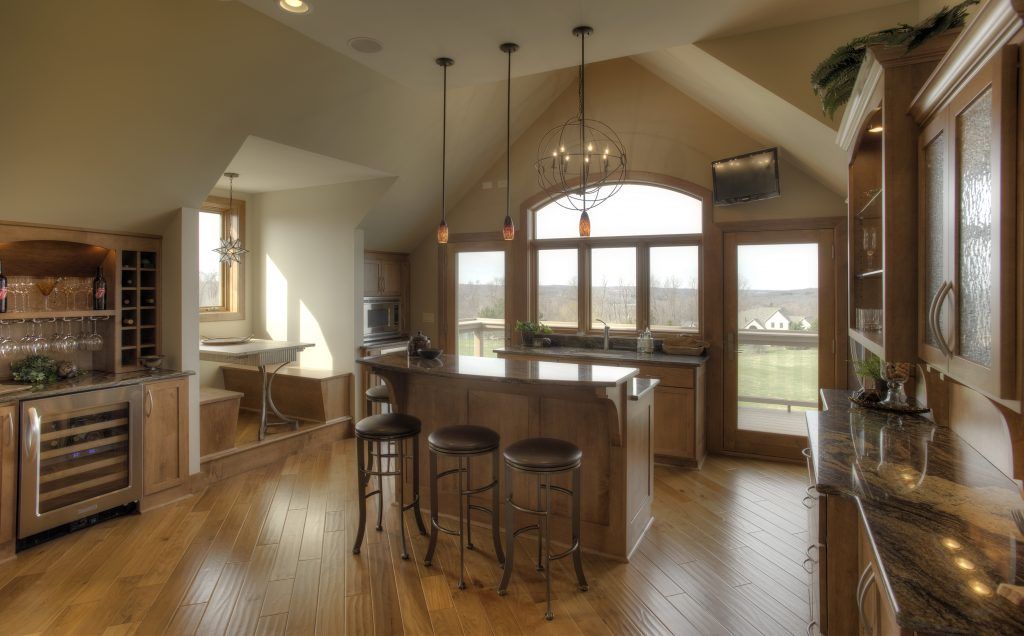 A kitchen with a large island and stools.