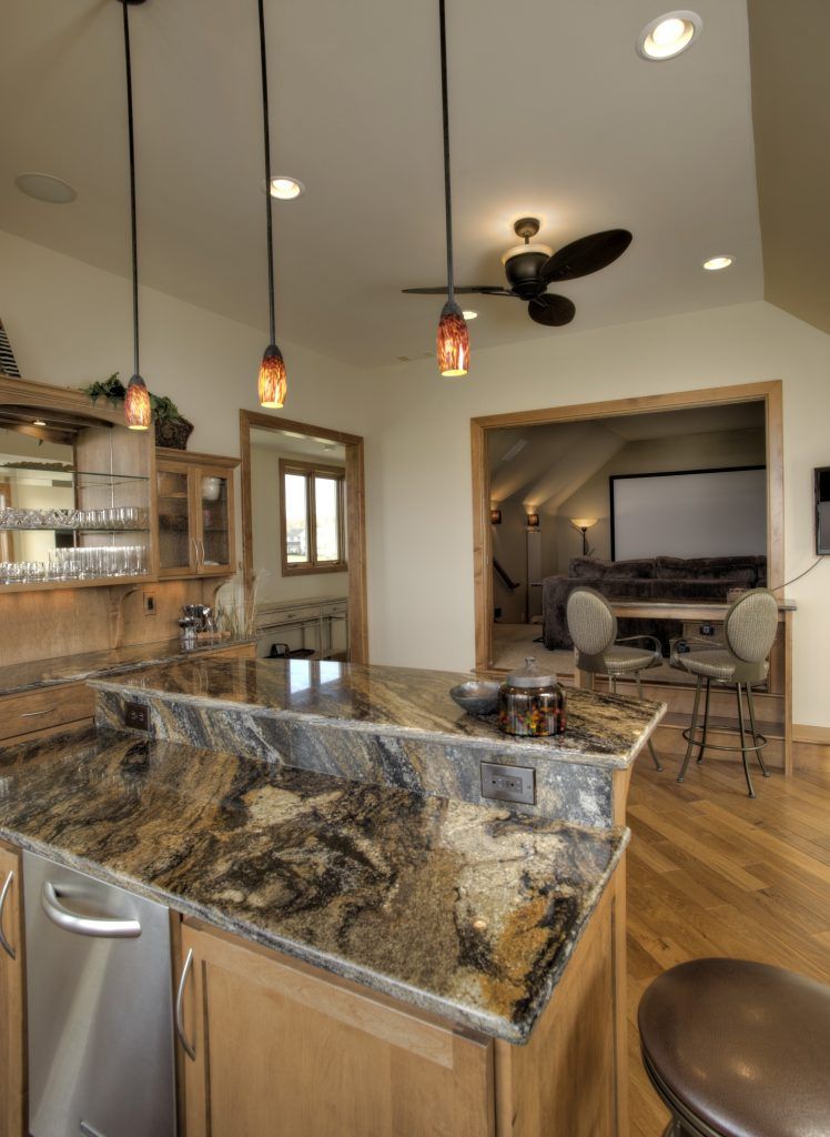 A kitchen with a granite counter top and a ceiling fan.