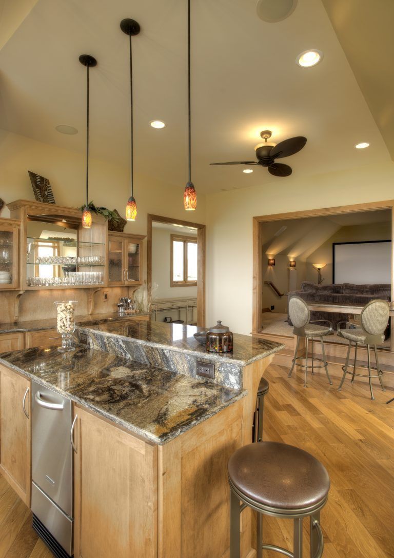 A kitchen with a large island and a ceiling fan.