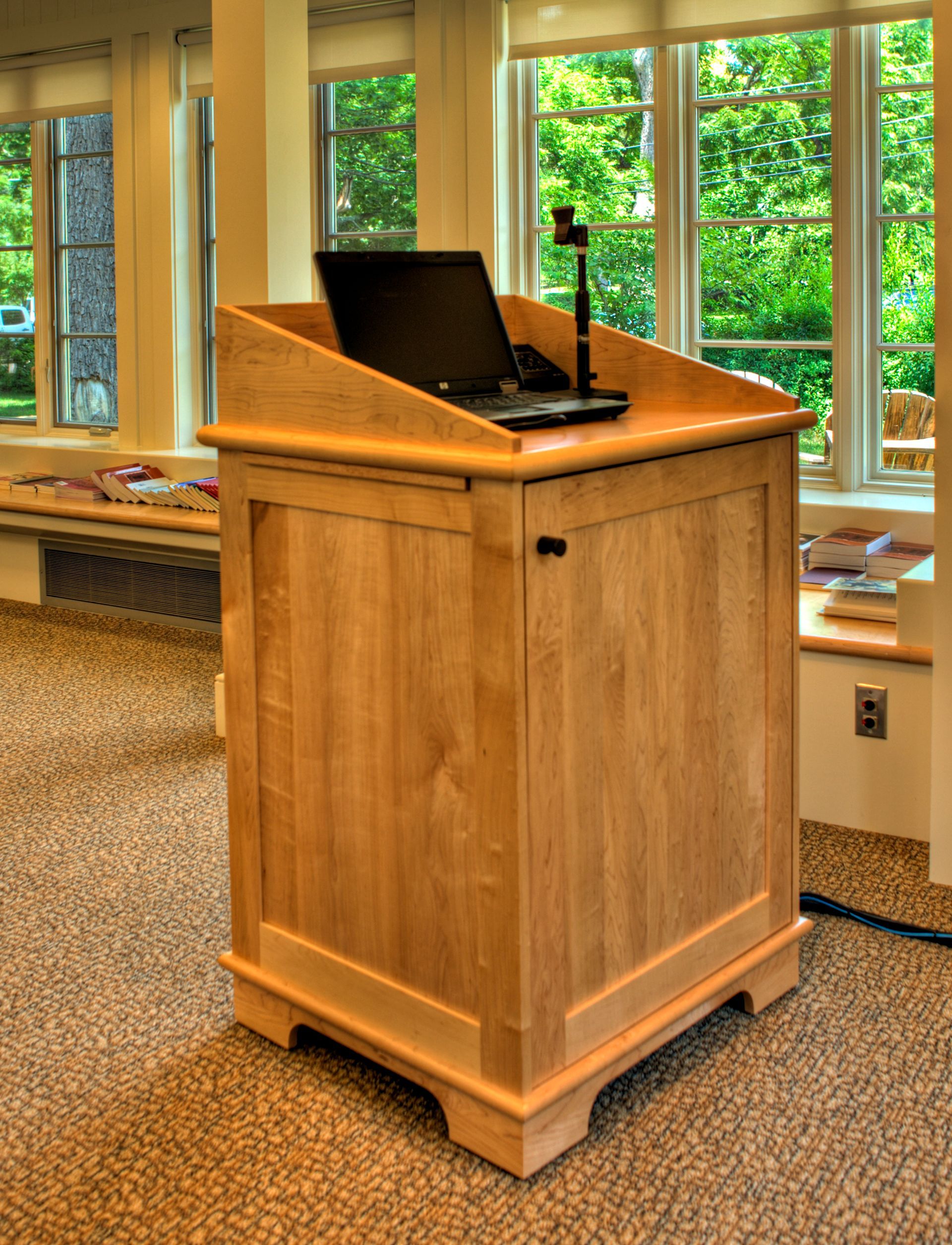A wooden pulpit with a laptop on top of it. 
