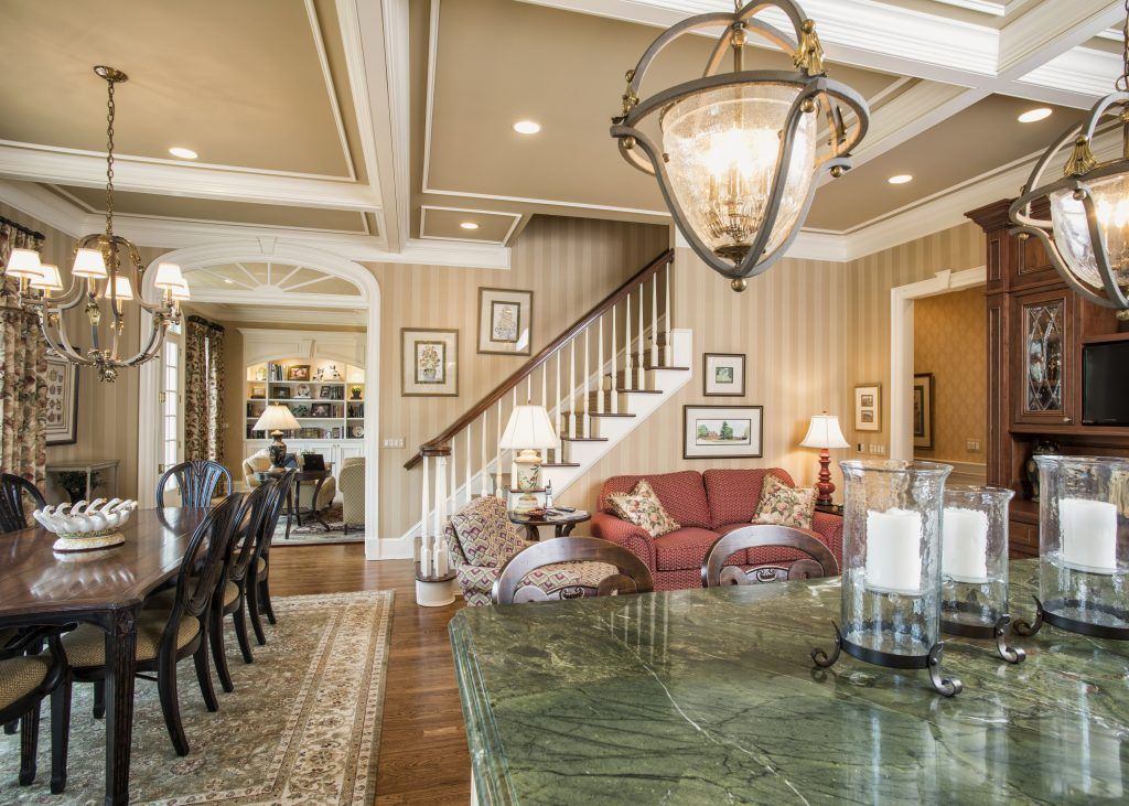 A living room with a staircase and a green counter top.