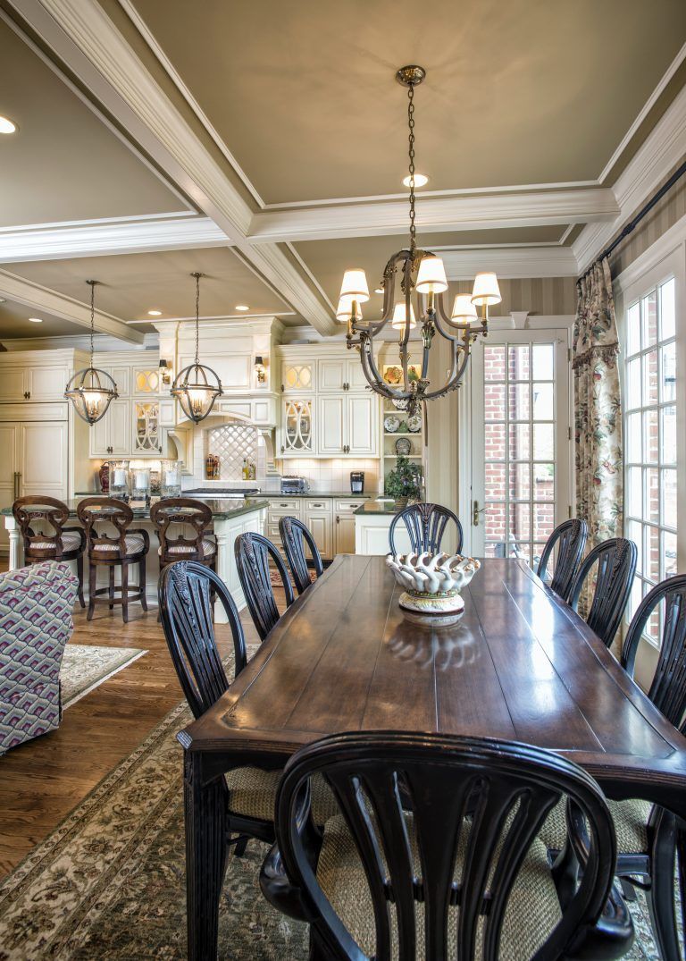 A dining room with a long wooden table and chairs and a chandelier.