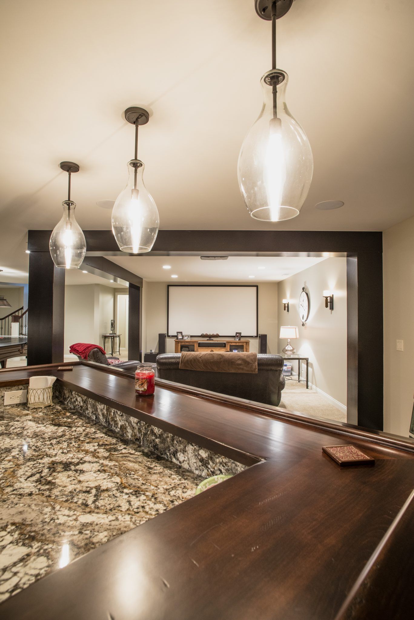 A bar in a living room with a projector screen.