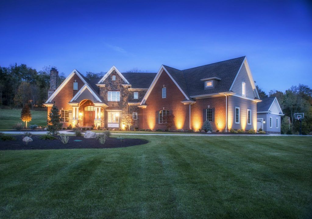 A large brick house is lit up at night.