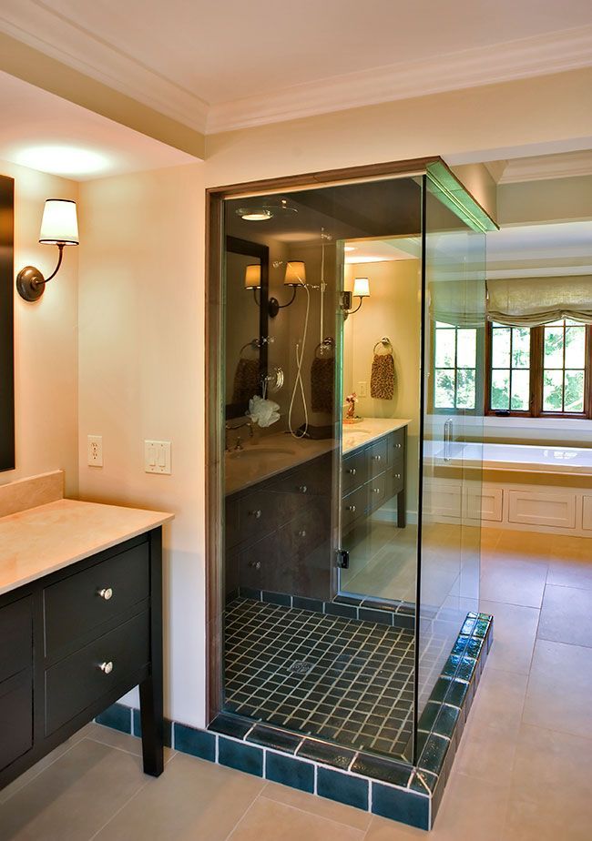 A bathroom with a walk in shower and a sink.