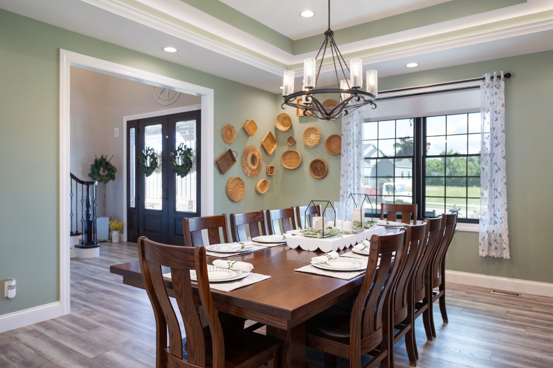 A dining room with a long wooden table and chairs and a chandelier.
