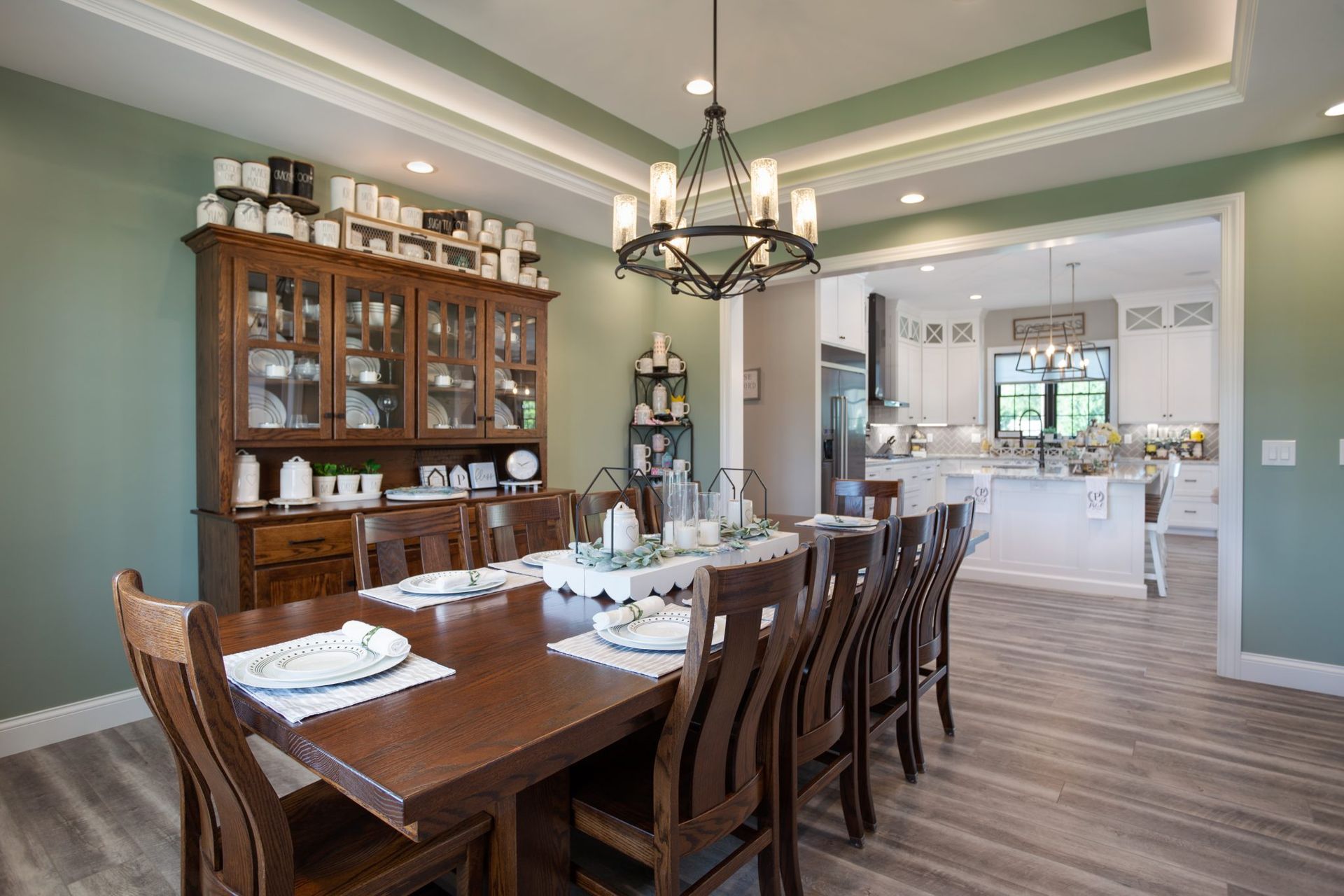 A dining room with a long wooden table and chairs and a chandelier.