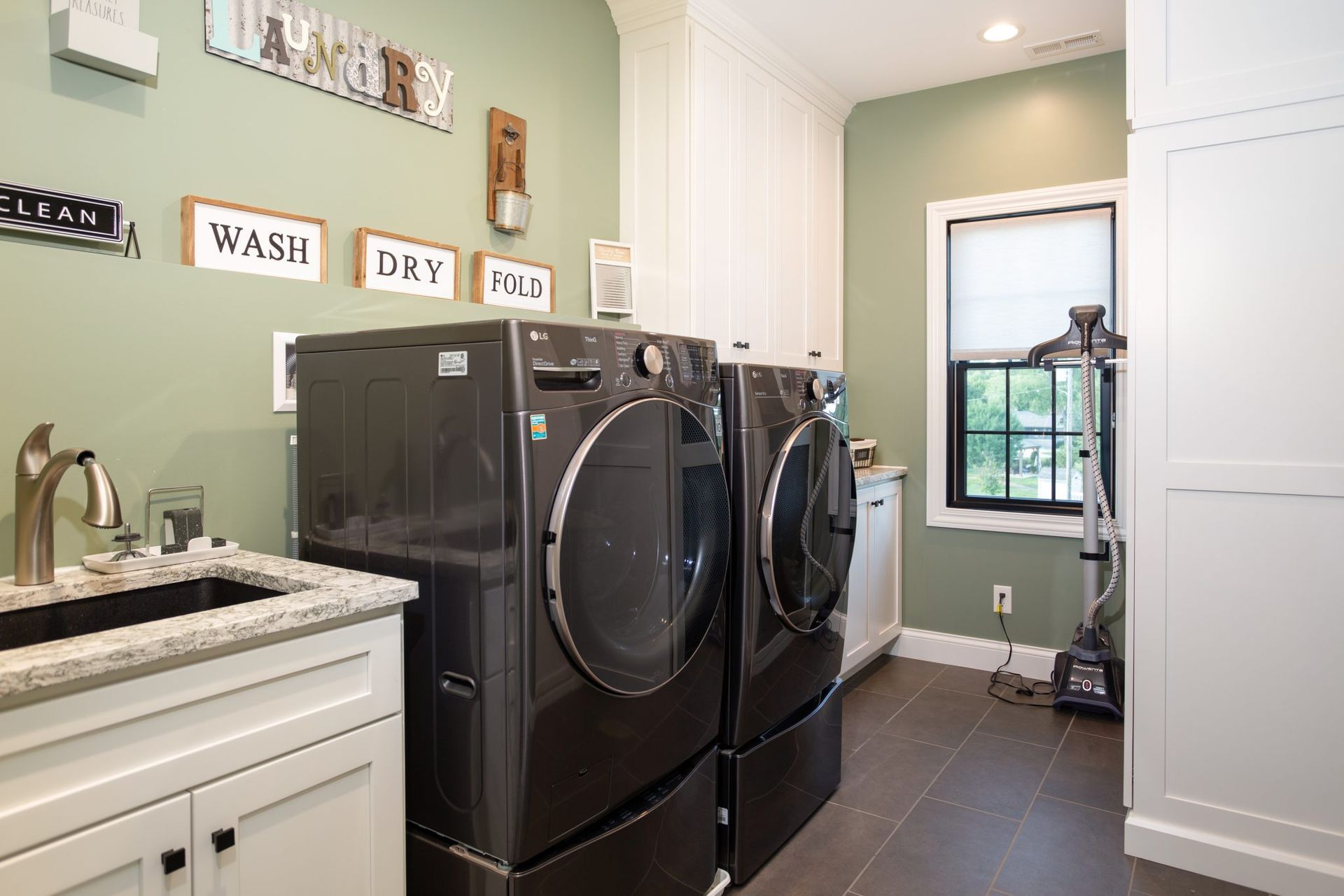 A laundry room with a washer and dryer and a sink.