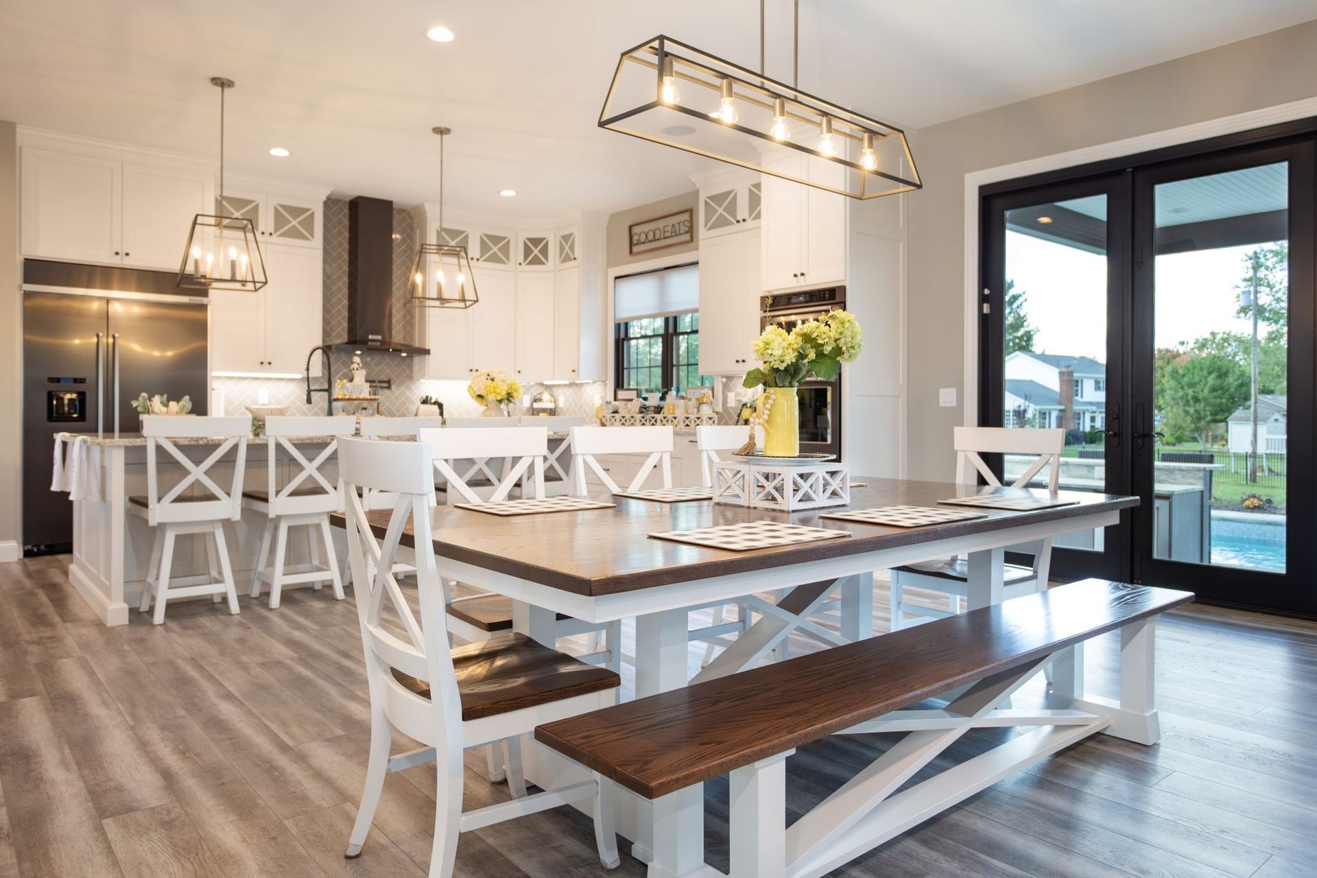 A dining room table with a bench and chairs in a kitchen.
