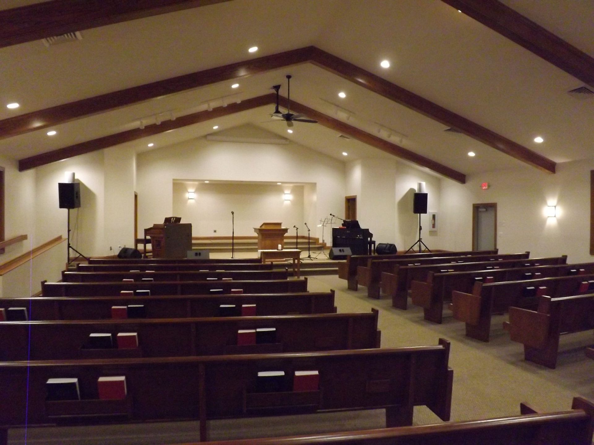 An empty church with wooden benches and a podium.