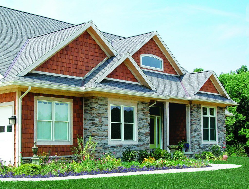 A large red and gray brick and stone house with a gray roof.