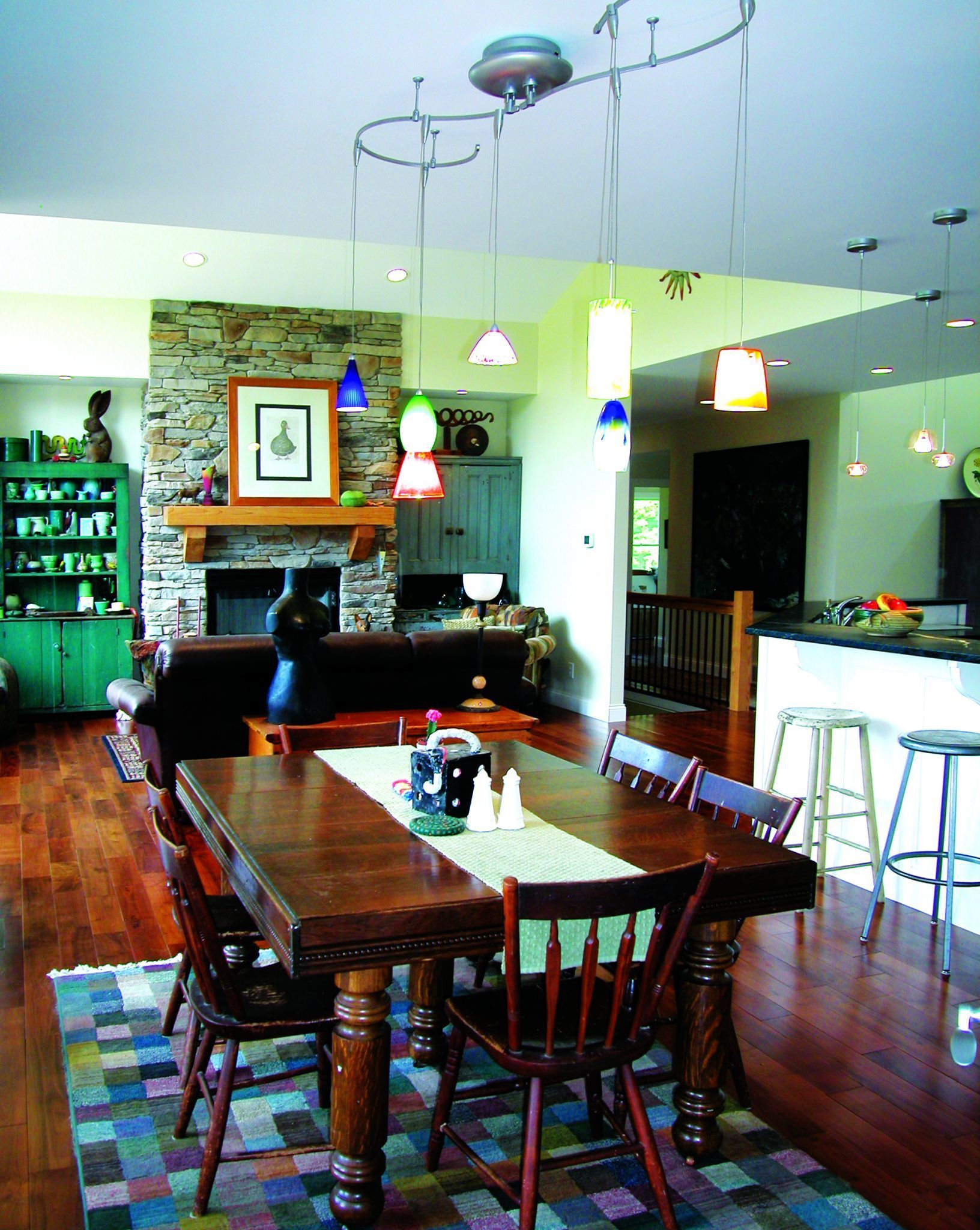 A dining room with a table and chairs and a fireplace.