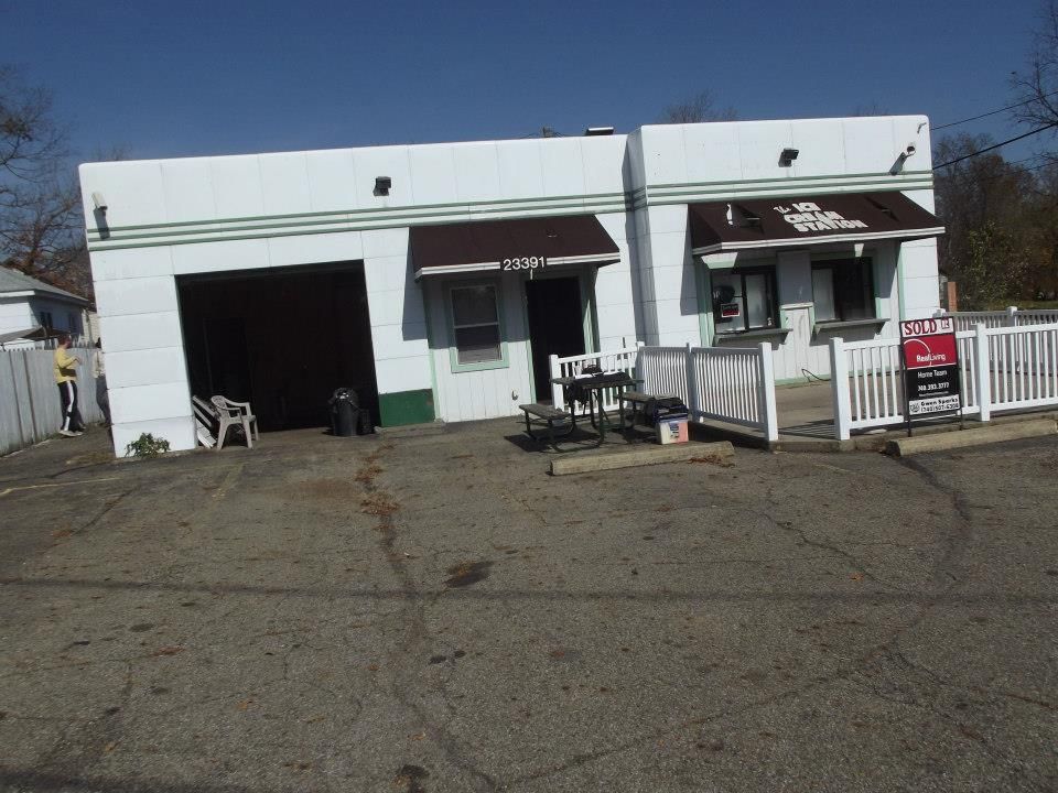 A white building with a brown awning and a sign that says ' coca cola ' on it.