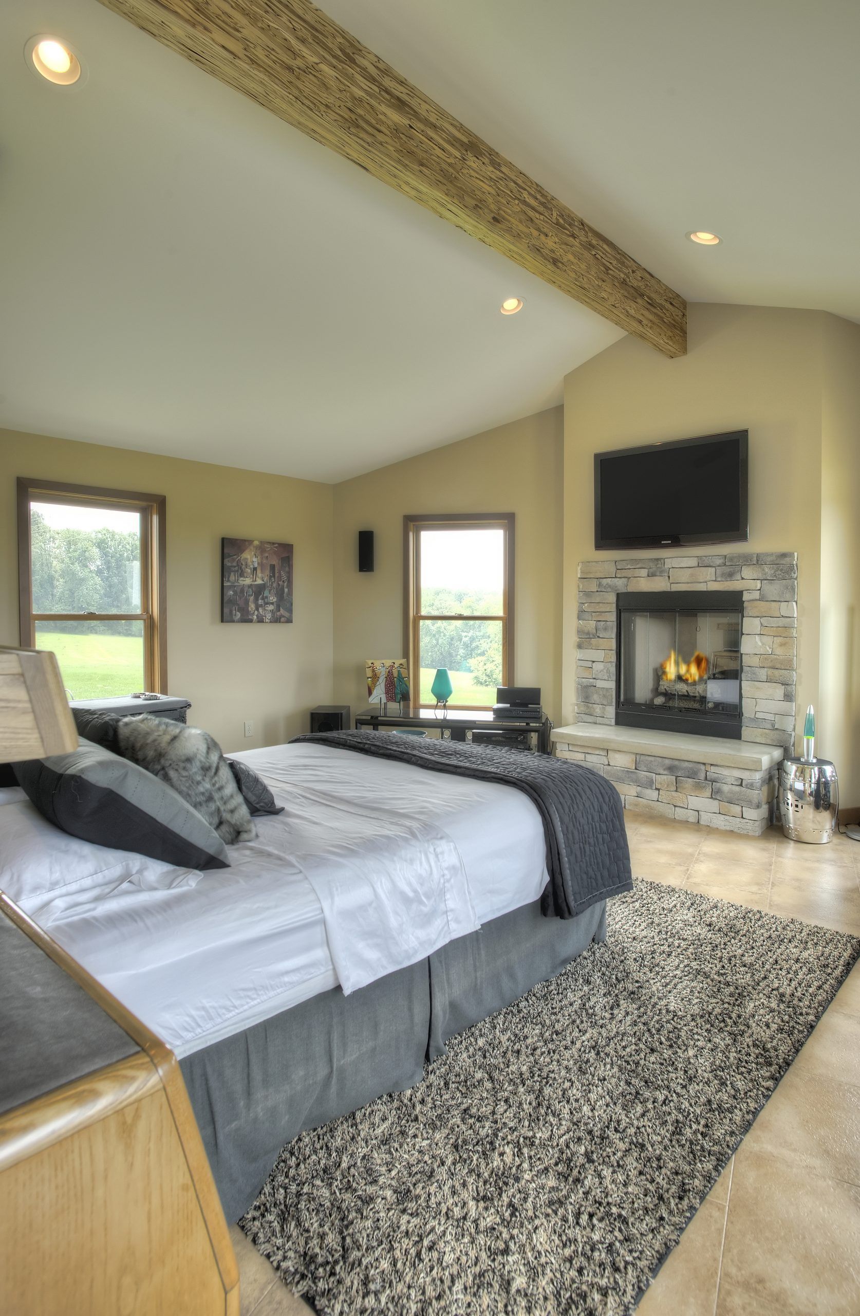 A bedroom with a fireplace and a large bed