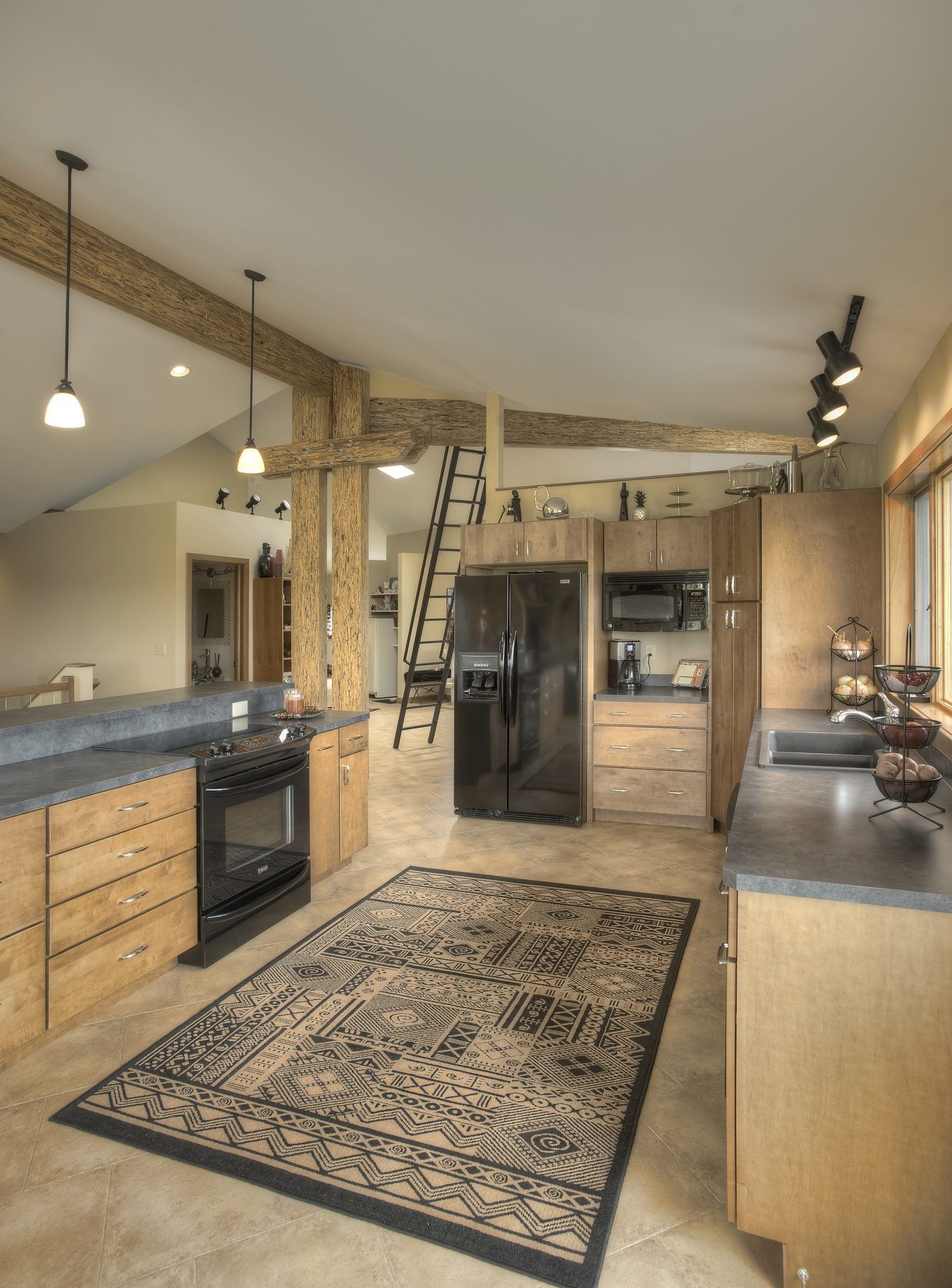 A kitchen with a rug on the floor and a black refrigerator