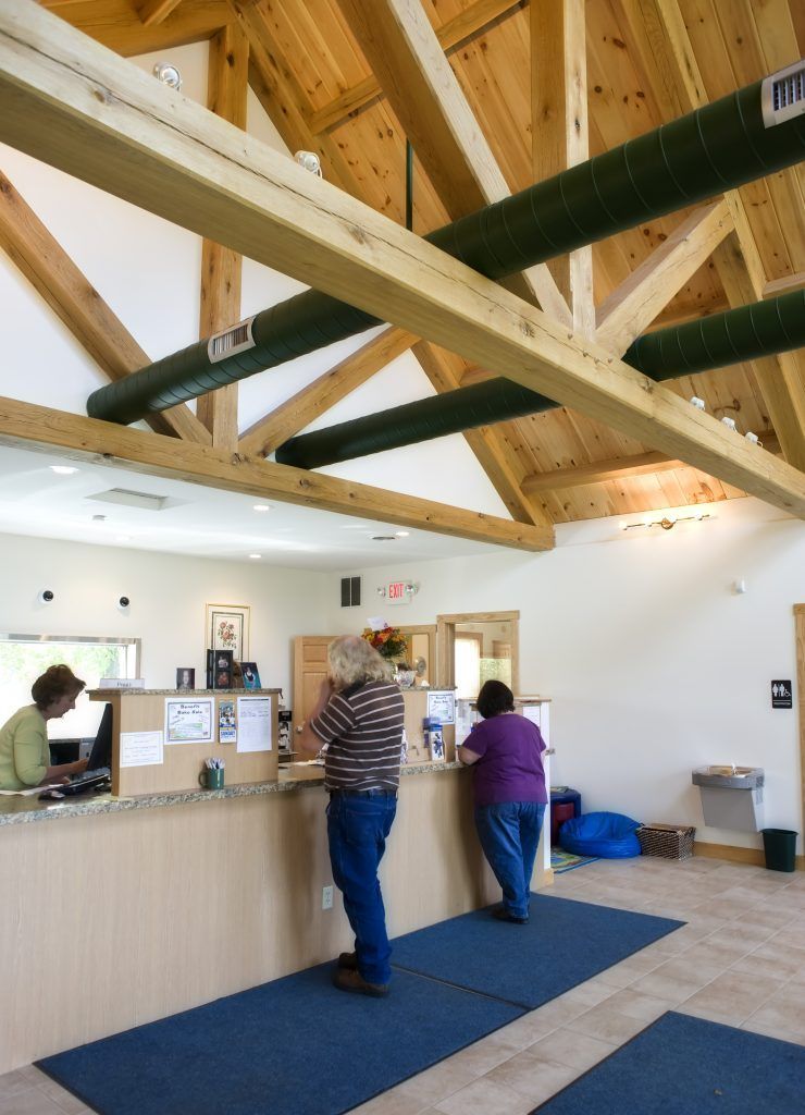 A couple of people standing at a counter in a building.