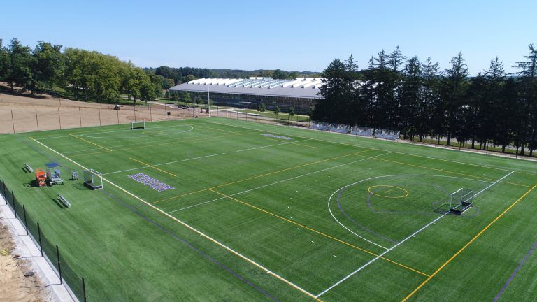 An aerial view of a soccer field with trees in the background.