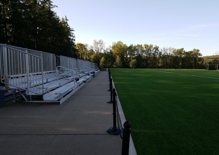 A football field with bleachers on the side of it.