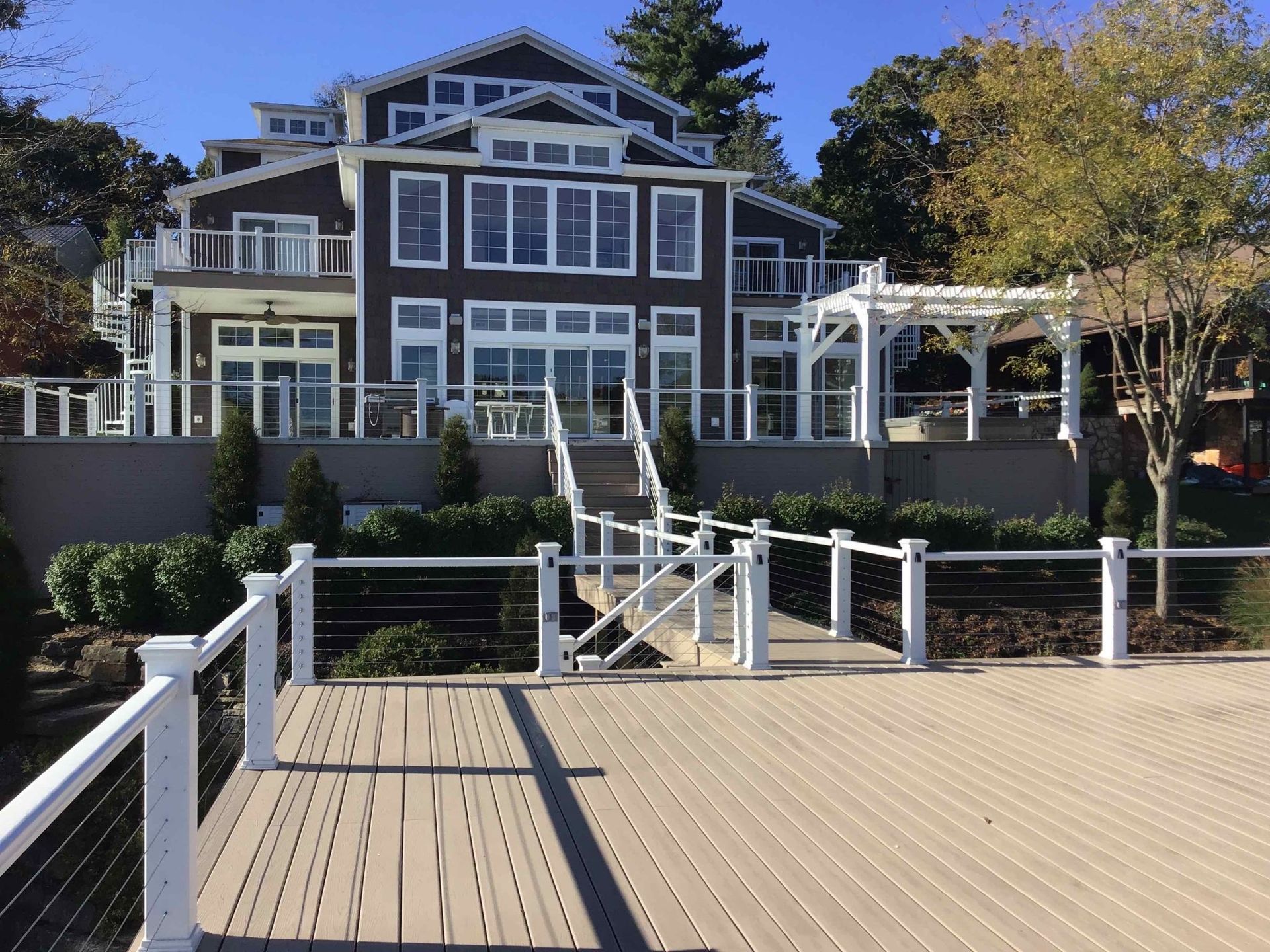 A large house with a wooden deck in front of it.