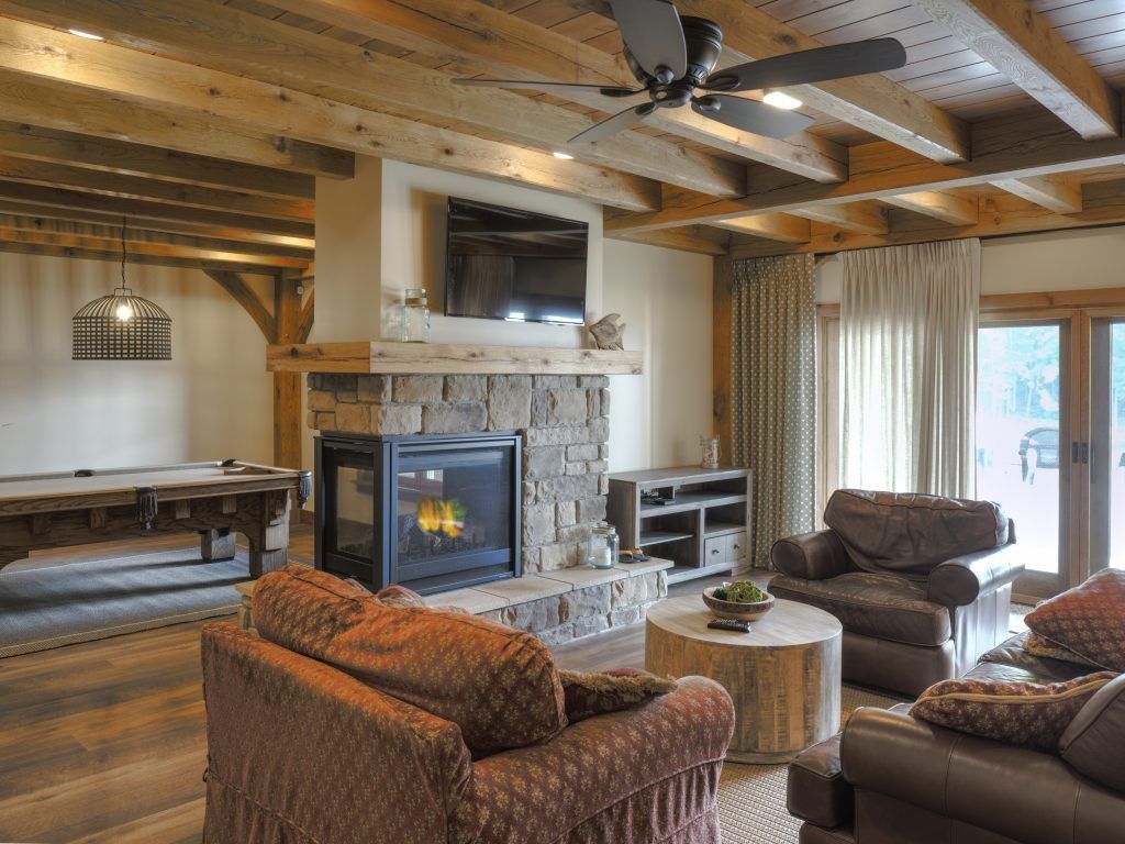 A living room with a fireplace and a pool table.