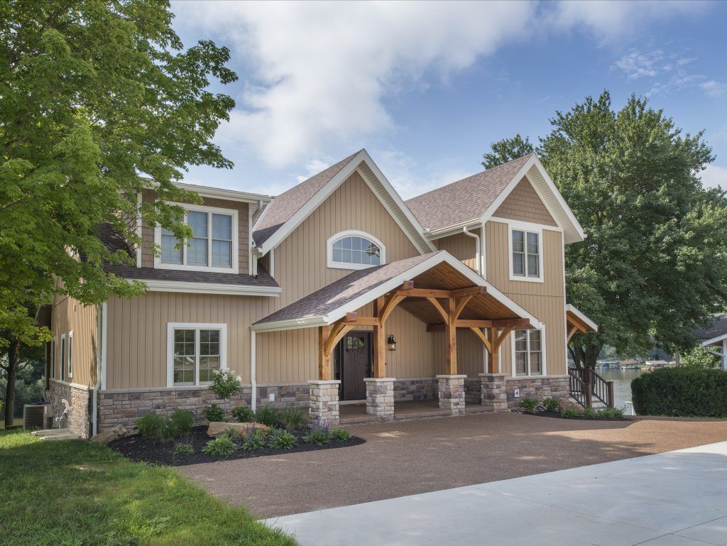 A large house with a porch and a brick driveway.