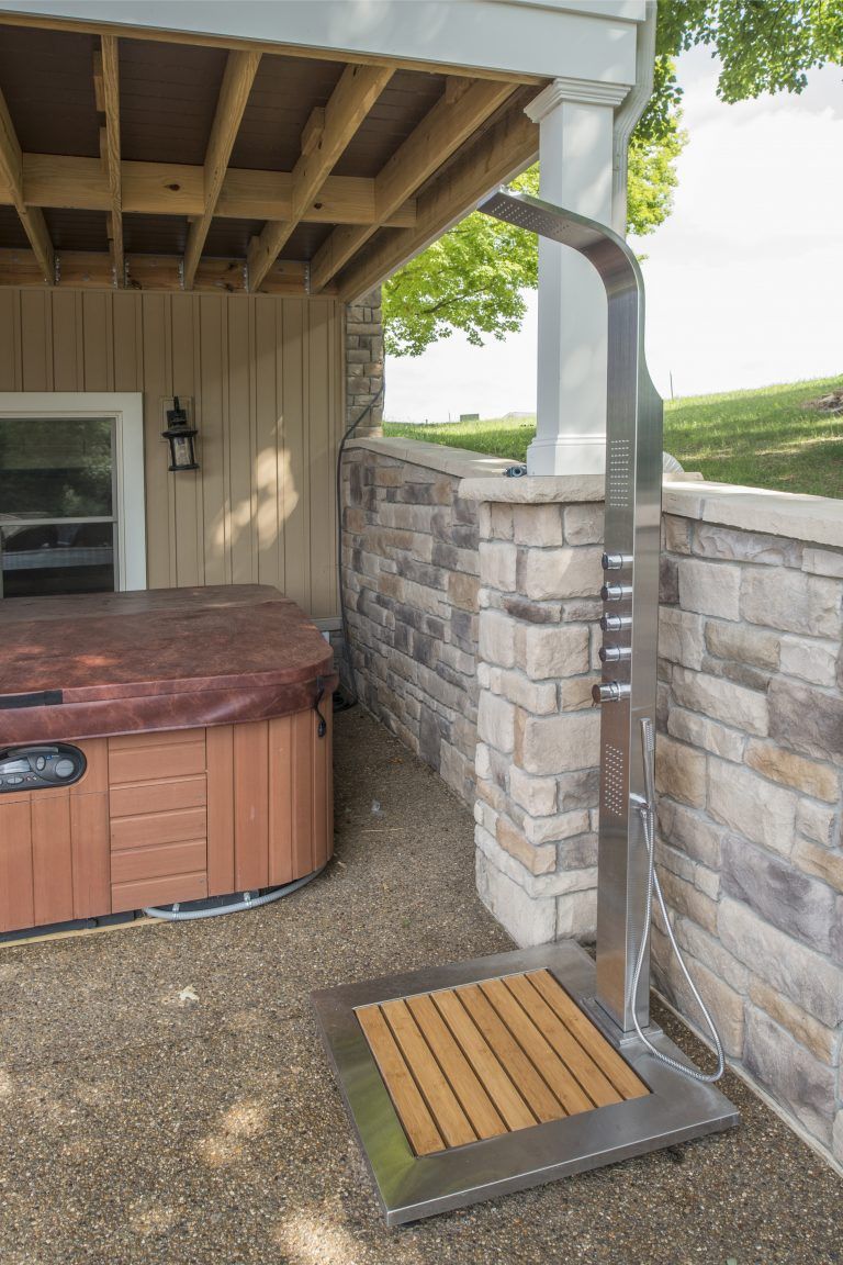 A hot tub with a shower next to it.