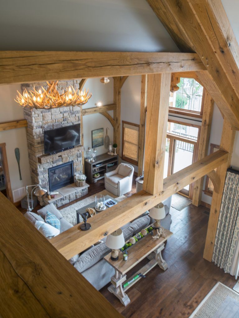 An aerial view of a living room with a fireplace and wooden beams.