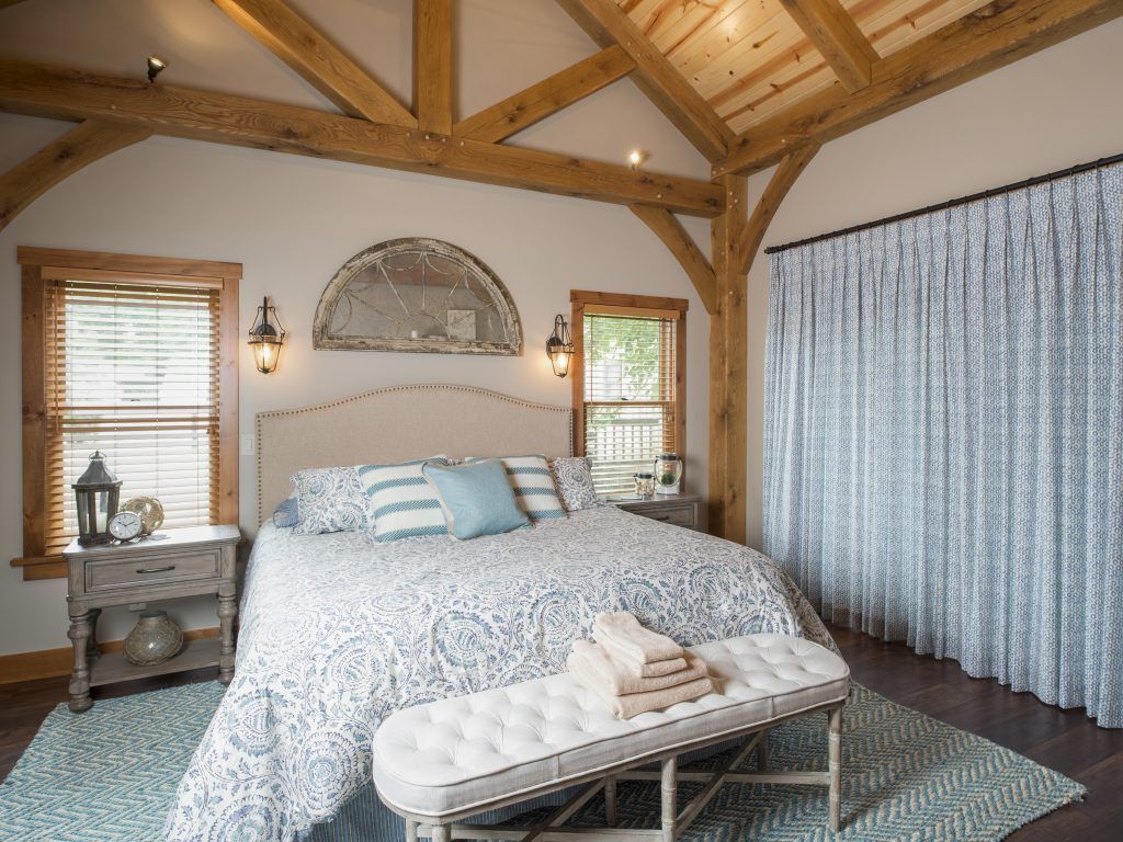 A bedroom with a king size bed and a bench.