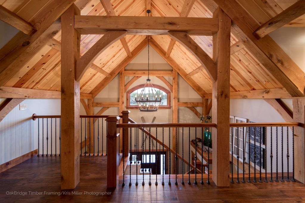 A wooden house with a staircase and a chandelier hanging from the ceiling.