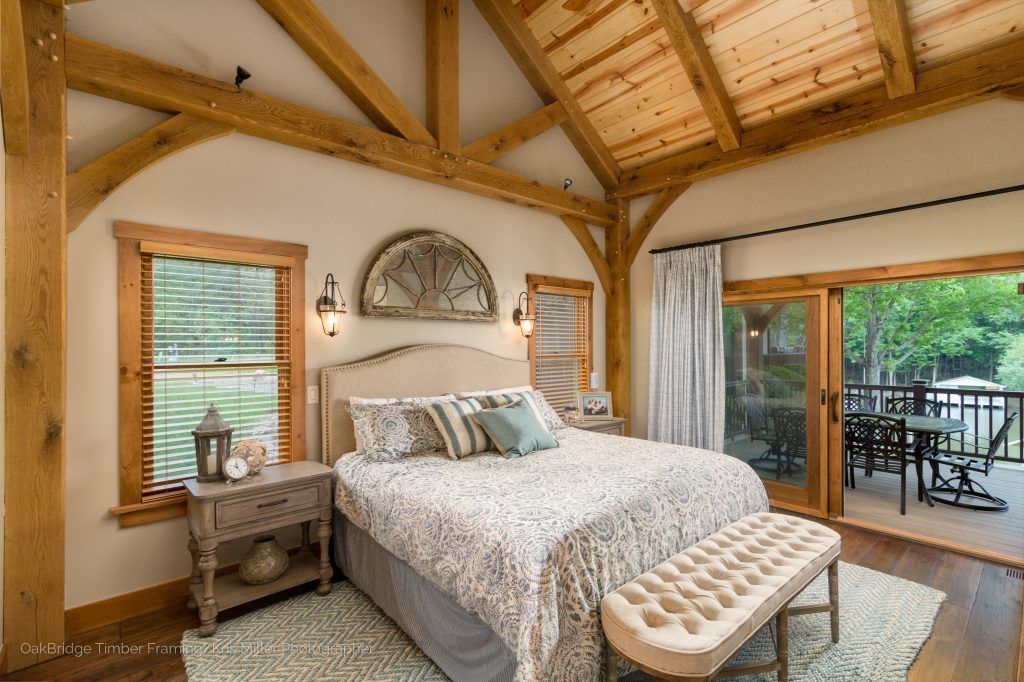 A bedroom with a bed , nightstand , bench and sliding glass doors.