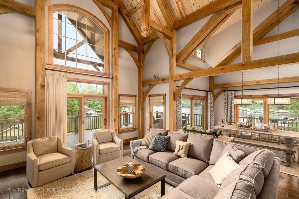 A living room with a wooden ceiling, a couch, chairs, and a coffee table.