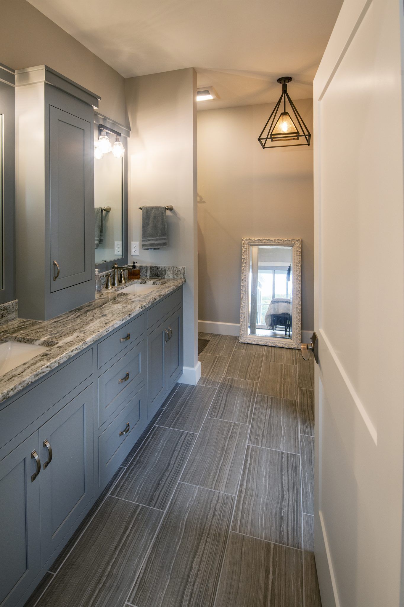 A bathroom with two sinks , two mirrors , and a large mirror.